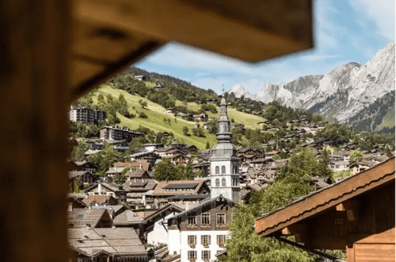 Point de vue sur le clocher de l'église de la Clusaz vu d'un chalet.