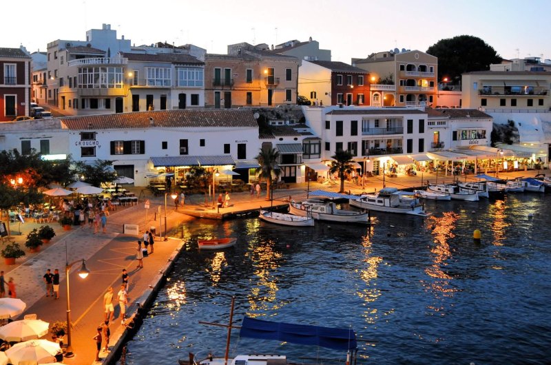 Petit port et ses ruelles éclairés à la tombée de la nuit à Minorque.